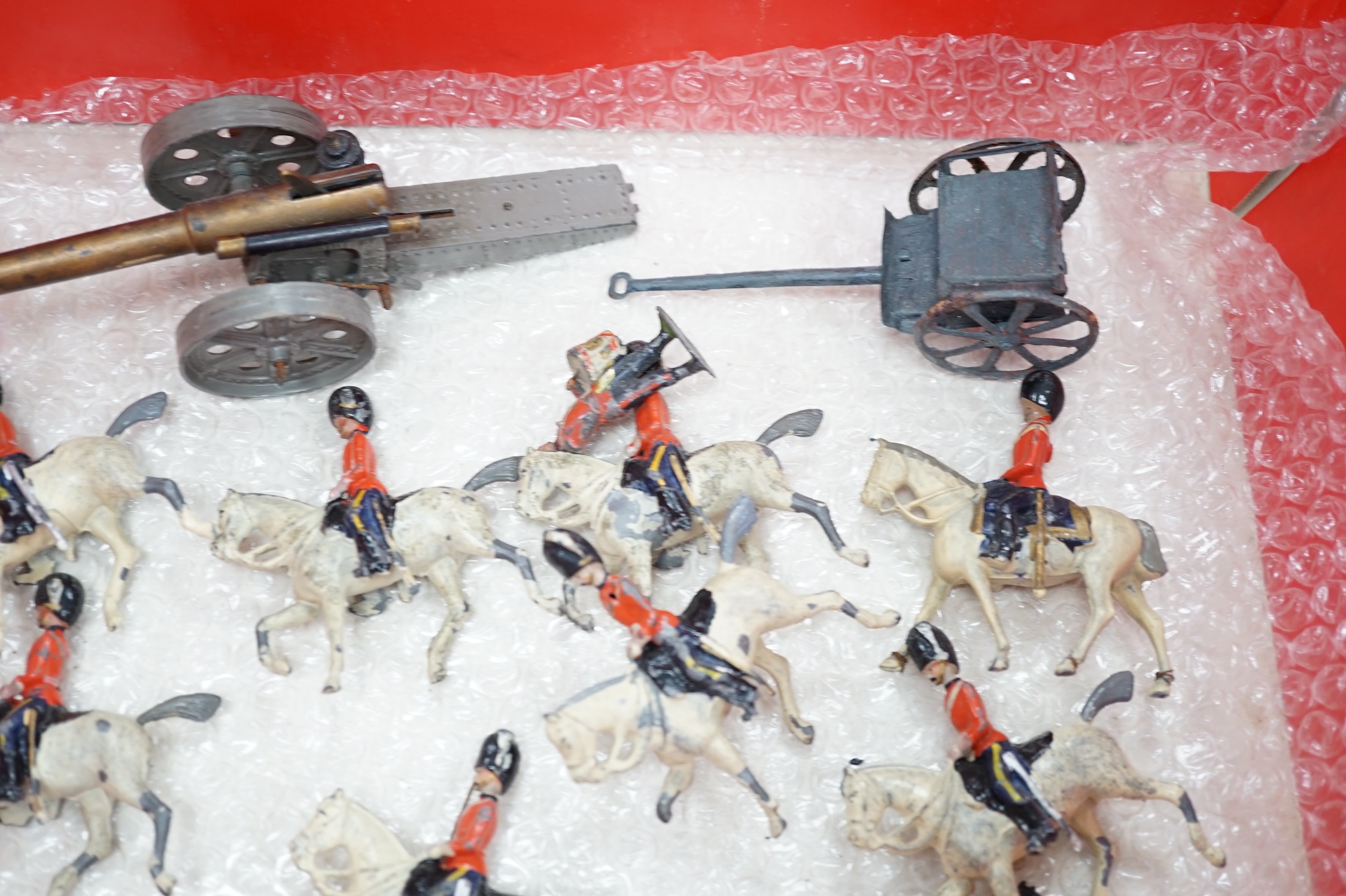 Forty-four early twentieth century Britains, etc. cavalry and infantry soldiers including; Scots Guards, mounted Grenadier Guards, bandsmen, etc. together with a field gun and tinplate lumber